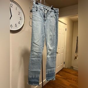 Good American Straight legged light wash jeans with tie dyed bottoms frayed
